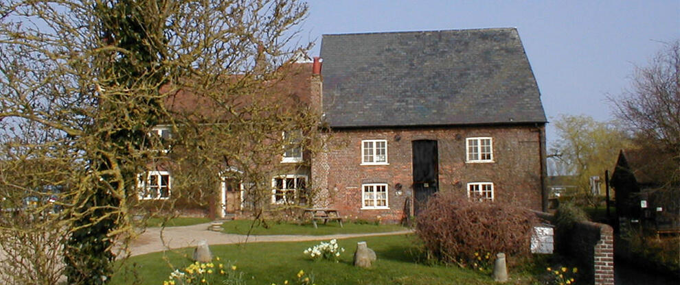 Redbournbury Watermill in early spring, with daffodils in the garden